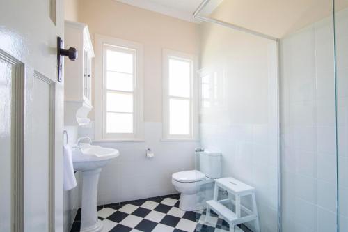 a white bathroom with a toilet and a sink at Victoria Street Apartments in Grafton