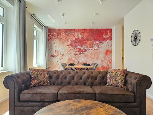 a living room with a brown couch and a table at HOMEBASE am Schloss - Perfekt für Gruppen - 4 Apartments - 1 Haus in Montabaur
