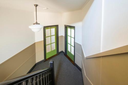 a staircase with two green doors in a building at Victoria Street Apartments in Grafton