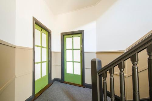 a staircase with green doors in a building at Victoria Street Apartments in Grafton