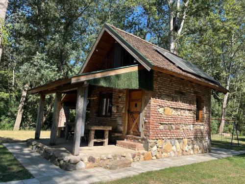 a small log cabin with a wooden door in a park at Vikendica Drina Mladenova suma in Čajići