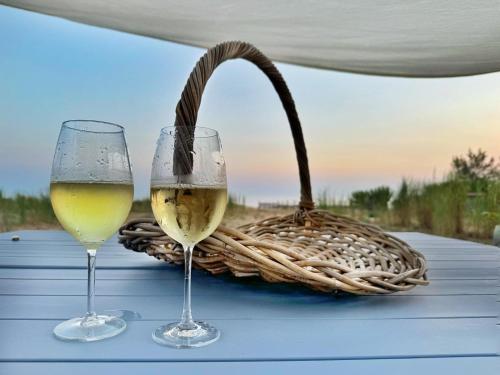 due bicchieri di vino bianco e un cestino su un tavolo di Fin Fiori a Menfi