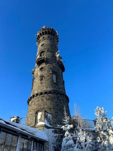 a lighthouse covered in snow on top of a building at Mezi stromy 165 in Česká Kamenice