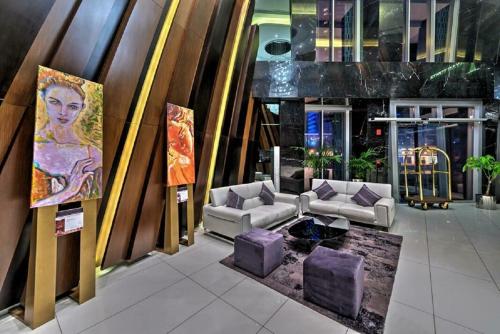 um saguão com sofás e uma pintura de uma mulher em Cayan Tower Dubai Marina - By Home Of Choice no Dubai