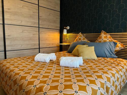 een slaapkamer met een groot bed met twee handdoeken erop bij Gîte Eden classer 3 étoiles in Colmar