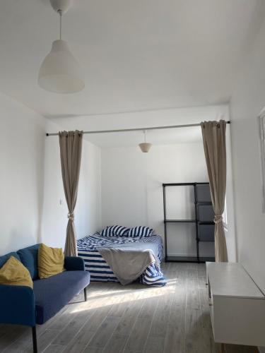 un salon avec un canapé et un lit dans l'établissement Chambre d'hôtes équipée et neuve, à Drancy