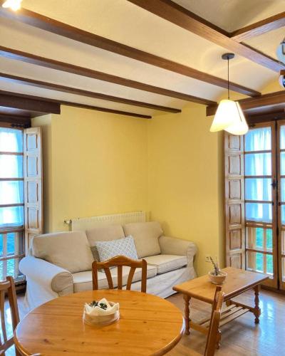 a living room with a couch and a table at Ahío San Martín, Apartamentos Rurales Casa de la Villa in San Martín de Oscos