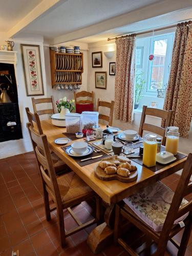 Una mesa de madera con comida en una sala de estar. en Redmoor, en Saint Day