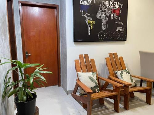two wooden chairs in a room with a blackboard at Apartamento no Centro in Palmas