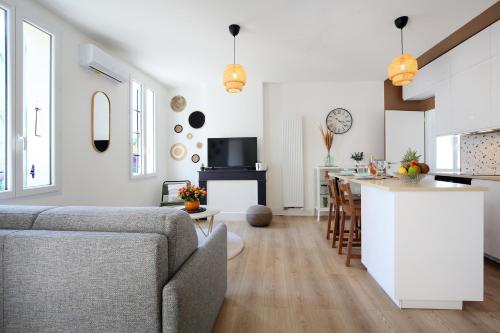 - une cuisine et un salon avec un canapé et un comptoir dans l'établissement L'Ethnique 7p - Climatisation - Jardin - Parking - Salle de Sport, à Toulouse