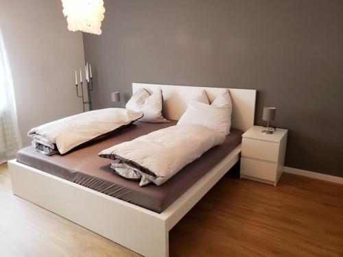 a bed with pillows on it in a room at FeWo,zentral,ruhig und 30 Minuten nach München in Pfaffenhofen an der Ilm