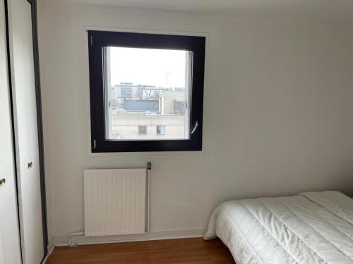 Cette chambre blanche dispose d'une fenêtre et d'un lit. dans l'établissement Appartement meublé de 04 chambres, à Boissy-Saint-Léger