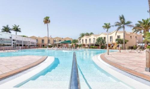 een zwembad op een resort met palmbomen bij Bungalow Eden Green Oasis in Maspalomas