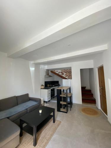 a living room with a couch and a table at Charmante Maison de Village in Aubignan