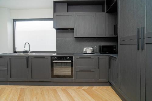 a kitchen with gray cabinets and a sink at MARVEL apartamentai in Kaunas