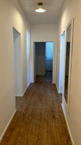 an empty room with wood floors and a hallway at Haus Crisan in Gobelsburg