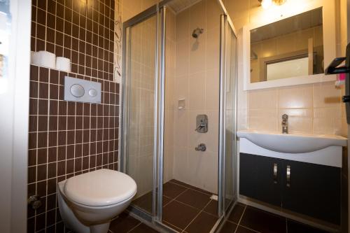 a bathroom with a toilet and a sink and a shower at Seymen Otel in Kizkalesi