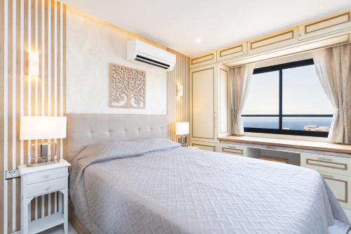 a bedroom with a white bed and a window at Apartment on the beach Paraiso Playa, Sea Views in Playa Paraiso