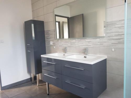 une salle de bain avec un lavabo et un miroir dans l'établissement Maison 3 chambres, à Parentis-en-Born