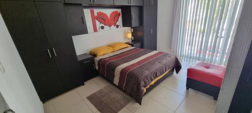 a small bedroom with a bed and a cabinet at Lomas San Pedro in Carrillo