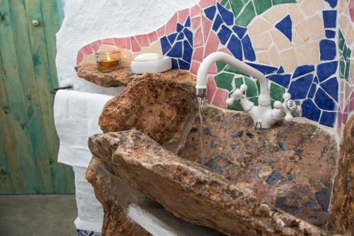 a bathroom with a stone sink with a mosaic wall at Balcones de Piedad in Los Balcones