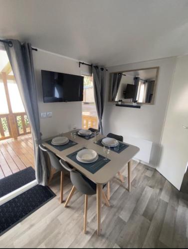 - une salle à manger avec une table dans une caravane dans l'établissement MH 639 6 à 7 personnes Tout équipé Climatisé Camping 4 étoiles Le Bois Dormant, à Saint-Jean-de-Monts