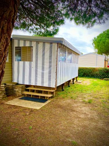 Une petite maison est assise sur le côté d'une maison dans l'établissement MH 639 6 à 7 personnes Tout équipé Climatisé Camping 4 étoiles Le Bois Dormant, à Saint-Jean-de-Monts