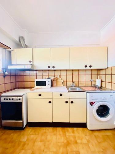 a kitchen with a washing machine and a sink at Caparica Terrace Beach Apartment in Costa da Caparica