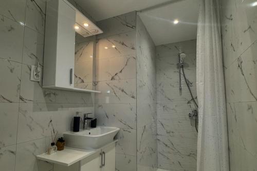 a white bathroom with a sink and a shower at Vila Varagic in Budva