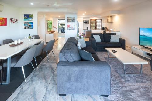 a living room with a couch and a table at Heliconia Grove - 3 bedroom - on Hamilton Island by HIHA in Hamilton Island