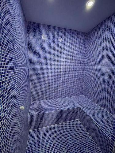 a blue tiled bathroom with a shower with blue tiles at Melisa Luxury Villa in Dosemealti