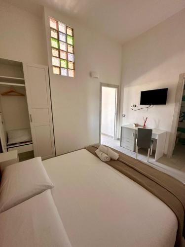 a bedroom with a bed and a desk and a television at Brezza di Mare Rooms Palinuro in Centola
