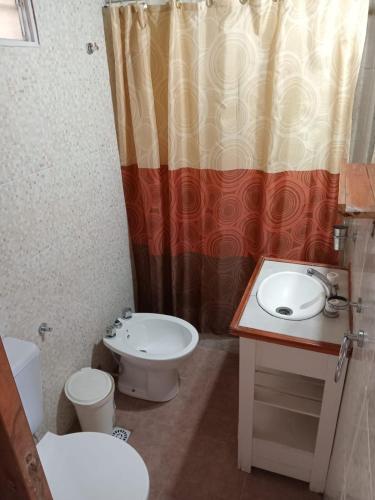 a bathroom with a sink and a toilet and a shower curtain at Los cuca in Santa Teresita