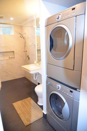 een wasmachine in een badkamer met toilet bij Hannah's Heavenly Home in Surrey