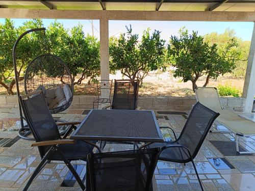 een tafel en stoelen op een patio met bomen bij Apartment Nada in Rogoznica
