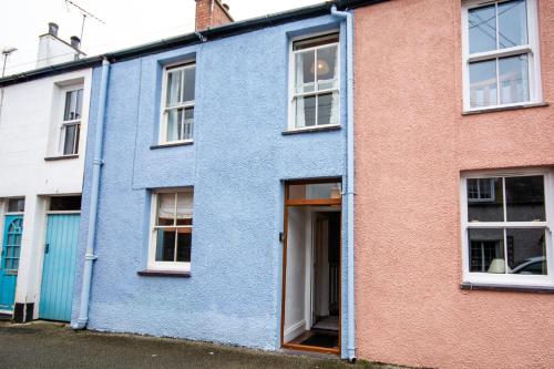 a blue house with white windows in a street at 26 Rosemary Lane in Beaumaris