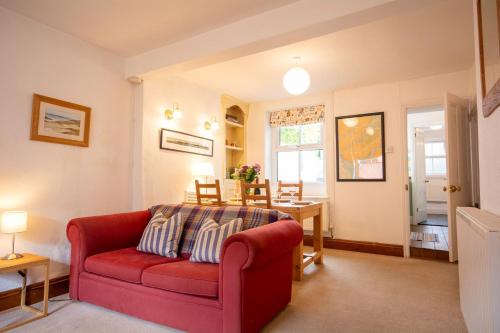a living room with a red couch and a table at 26 Rosemary Lane in Beaumaris