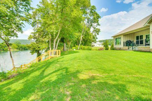 a large yard next to a house with a body of water at Flippin Home with Deck and Grill Steps to White River in Flippin