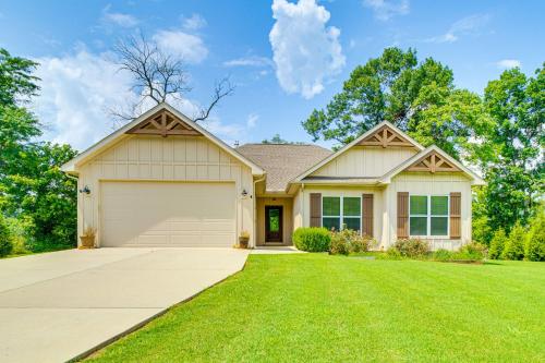 a house with a garage on a green lawn at Flippin Home with Deck and Grill Steps to White River in Flippin