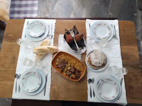 a table with plates of food on a table at Casa do Forno FR in Mondim de Basto