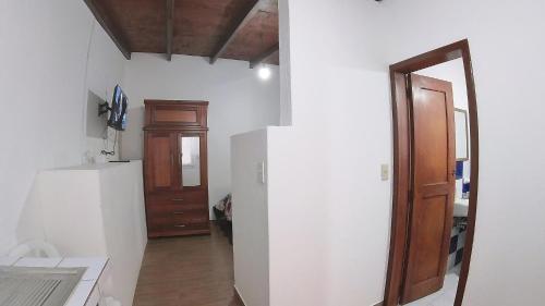 a kitchen with a refrigerator and a wooden door at Hotel Suite Central Park Tababela in Quito