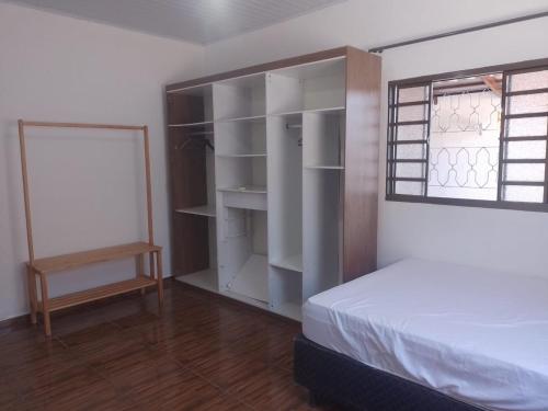 ein Schlafzimmer mit einem Bett und einem Fenster in der Unterkunft Aurora dos Pireneus in Pirenópolis