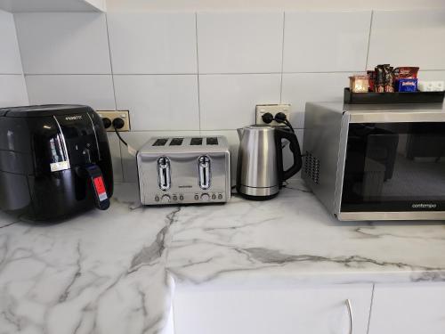 a kitchen counter with a coffee maker and a microwave at Inverell Motel in Inverell