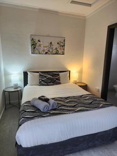 a bedroom with a large bed with towels on it at Inverell Motel in Inverell