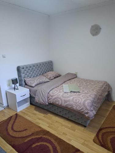 a bedroom with a bed with a nightstand and a bed sidx sidx at Tara Bozic Apartmani in Kaludjerske Bare