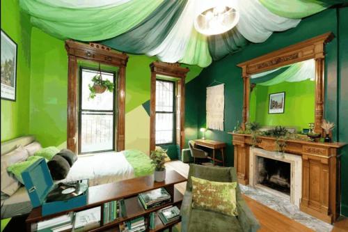 a living room with green walls and a fireplace at The Green Room: 70s Groove Themed Studio in New York
