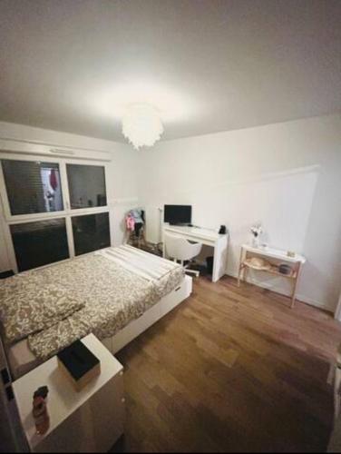 - une chambre avec un lit et un bureau dans l'établissement Appartement neuf cosy, à Saint-André
