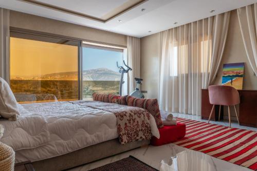 a bedroom with a bed and a large window at tayyurt host in Agadir