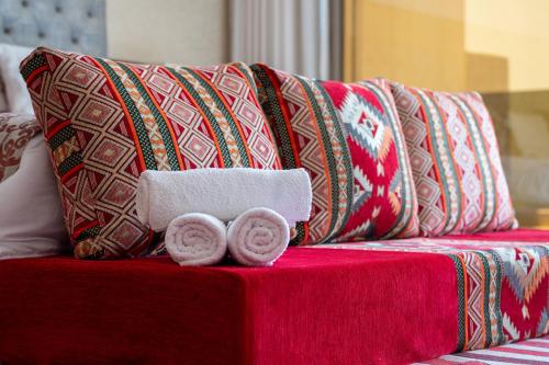 a red couch with pillows and two donuts on it at tayyurt host in Agadir