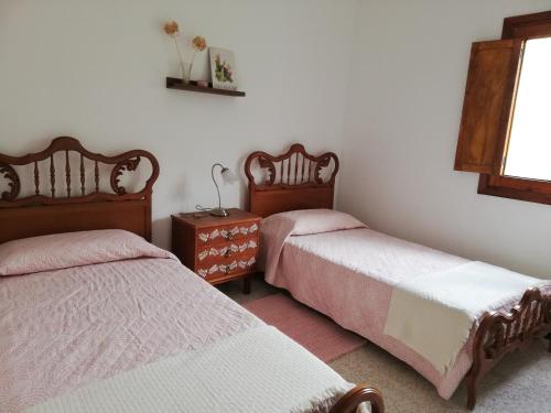 a bedroom with two beds and a window at Casa La Parra in Tejeda